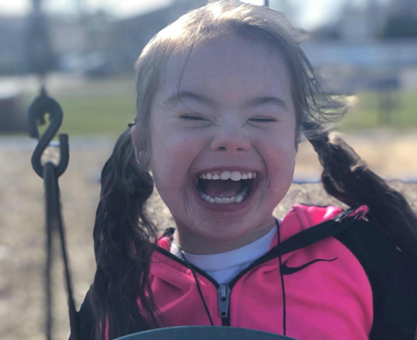Little girl smiling on swing